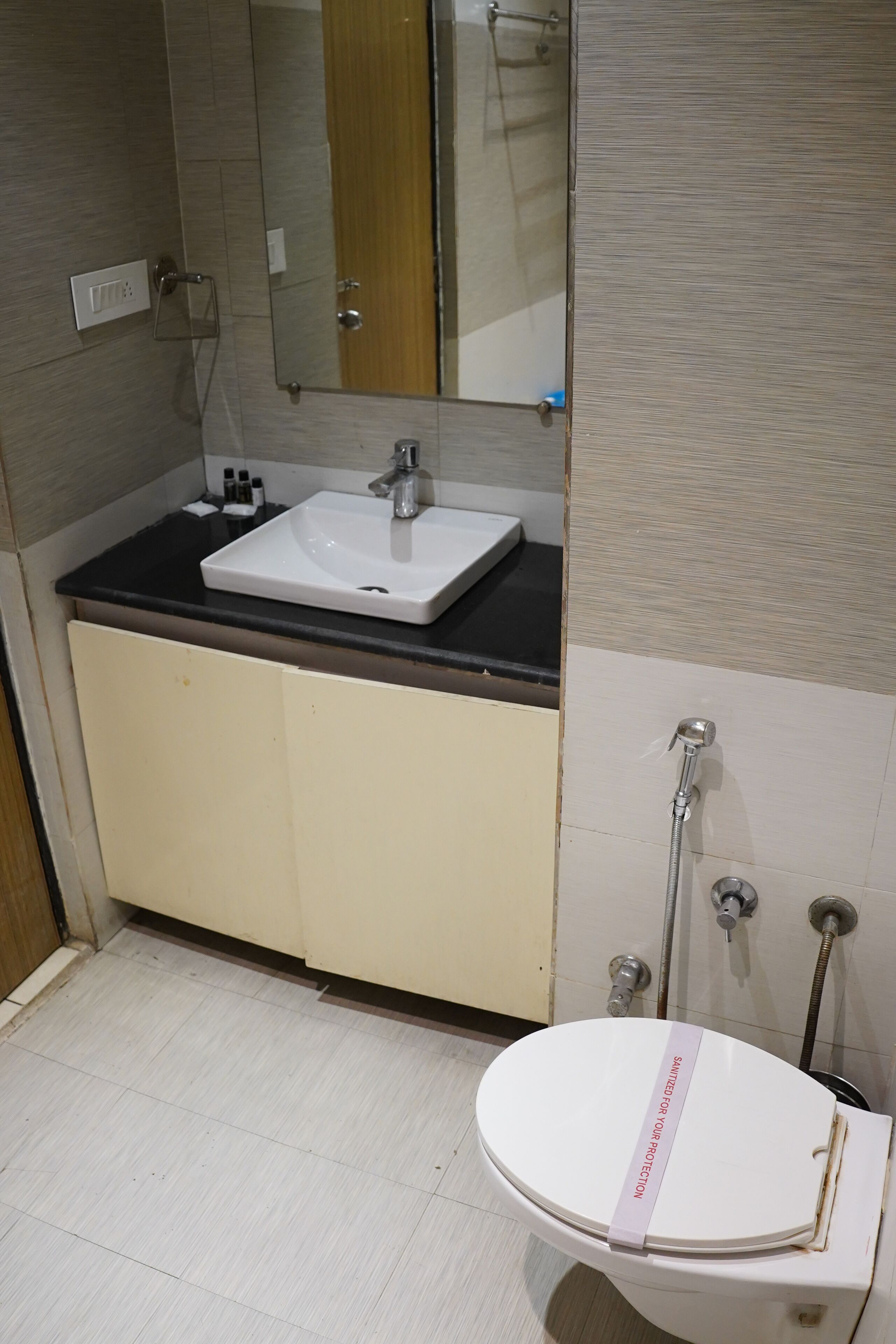 A bathroom with a white sink, a mirror, and a toilet.