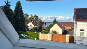 A skylight window with a view of residential houses and a clear sky. - Country house by the lake with fenced plot in Brandenburg an der Havel (Brandenburg)
