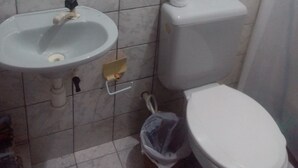 Ein Badezimmer mit Waschbecken, Toilette und Mülleimer.