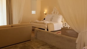 Um quarto espaçoso com uma cama grande, um espaço de estar e um banheiro separado com banheira.
