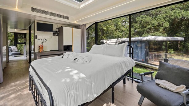 Une chambre moderne dotée d’un grand lit, d’un coin salon et offrant une vue sur l’extérieur.