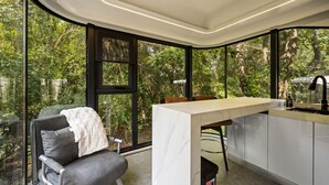 Une cuisine moderne dotée d’un plan de travail en marbre, d’un évier et d’un coin repas avec un banc et une table.
