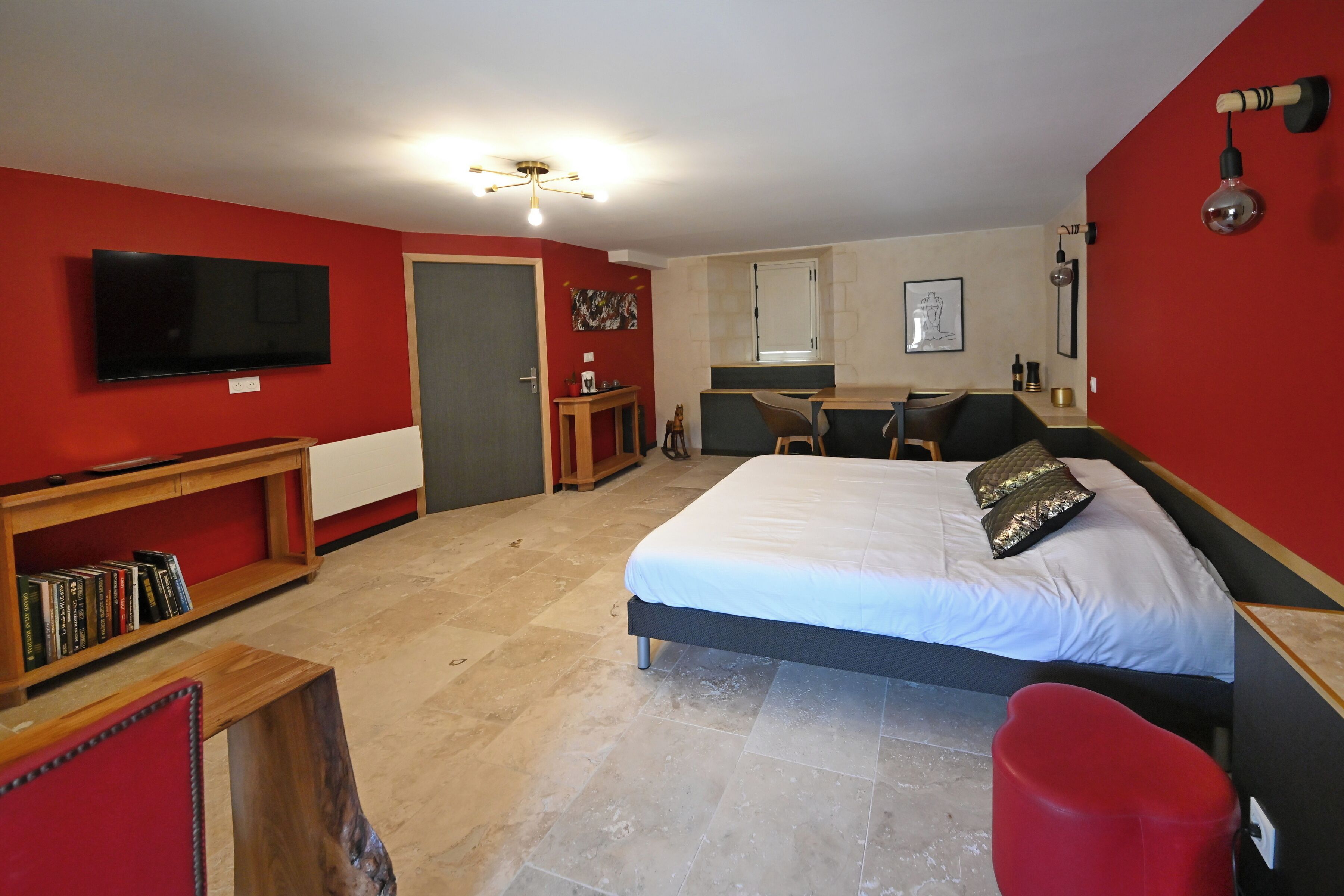 Une chambre à coucher avec un lit, une télévision, un bureau et une chaise.