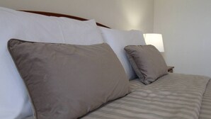 Una cama con una colcha a rayas y dos almohadas.
