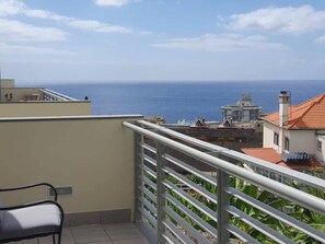 Un balcon avec vue sur la mer et les bâtiments.