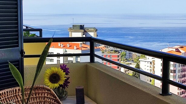 A balcony with a view of the sea and buildings. - Jardim Sol Holiday Apartment, Jardim Sol Holiday Apartment (Funchal)