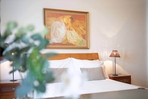 A bedroom with a bed, a nightstand, a lamp, and a painting on the wall. - Elsa's Place, Elsa's Place . (Funchal)