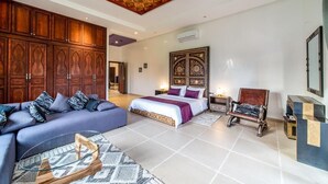 A spacious bedroom with a large bed, a sofa, a wooden cabinet, and a decorative ceiling. - Luxury stay near Marrakech with mountain views, pool, and family fun (Marrakesh)