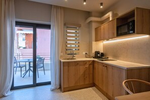 Suite Deluxe | Cocina privada | Frigorífico pequeño, microondas, placa de cocina y utensilios de cocina