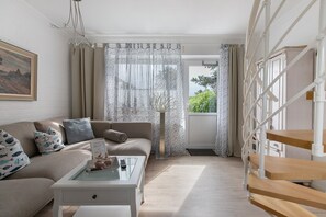 Ein Wohnzimmer mit einer Couch, einem Couchtisch und einer Treppe.