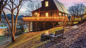 A large house with a balcony, a fire pit, and a bench. - Walk to BE | Hot Tub, Game Room + Ski Access (Banner Elk)