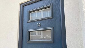 Une porte bleu foncé avec trois fenêtres et le numéro 14.