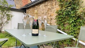 A table with a bottle of Moët & Chandon champagne and four glasses. - Sleeps 10 with private garden (Gloucestershire)