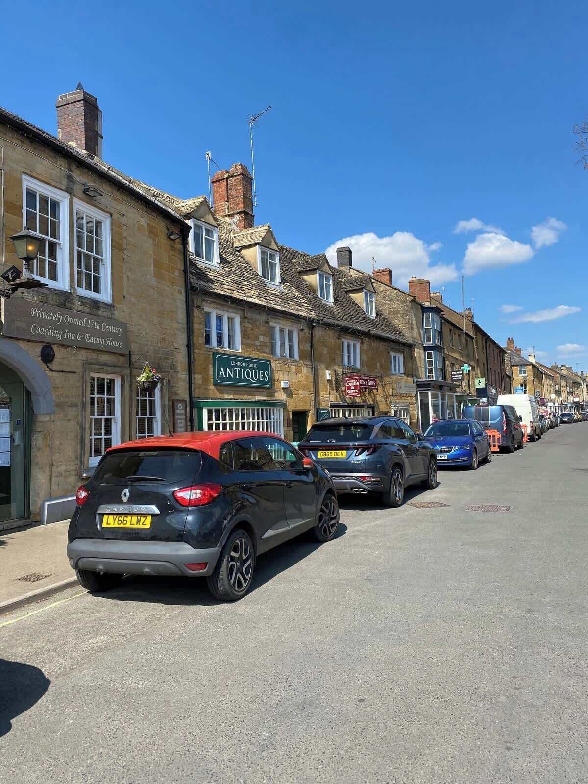 A street with parked cars and a building labeled "London House Antiques".