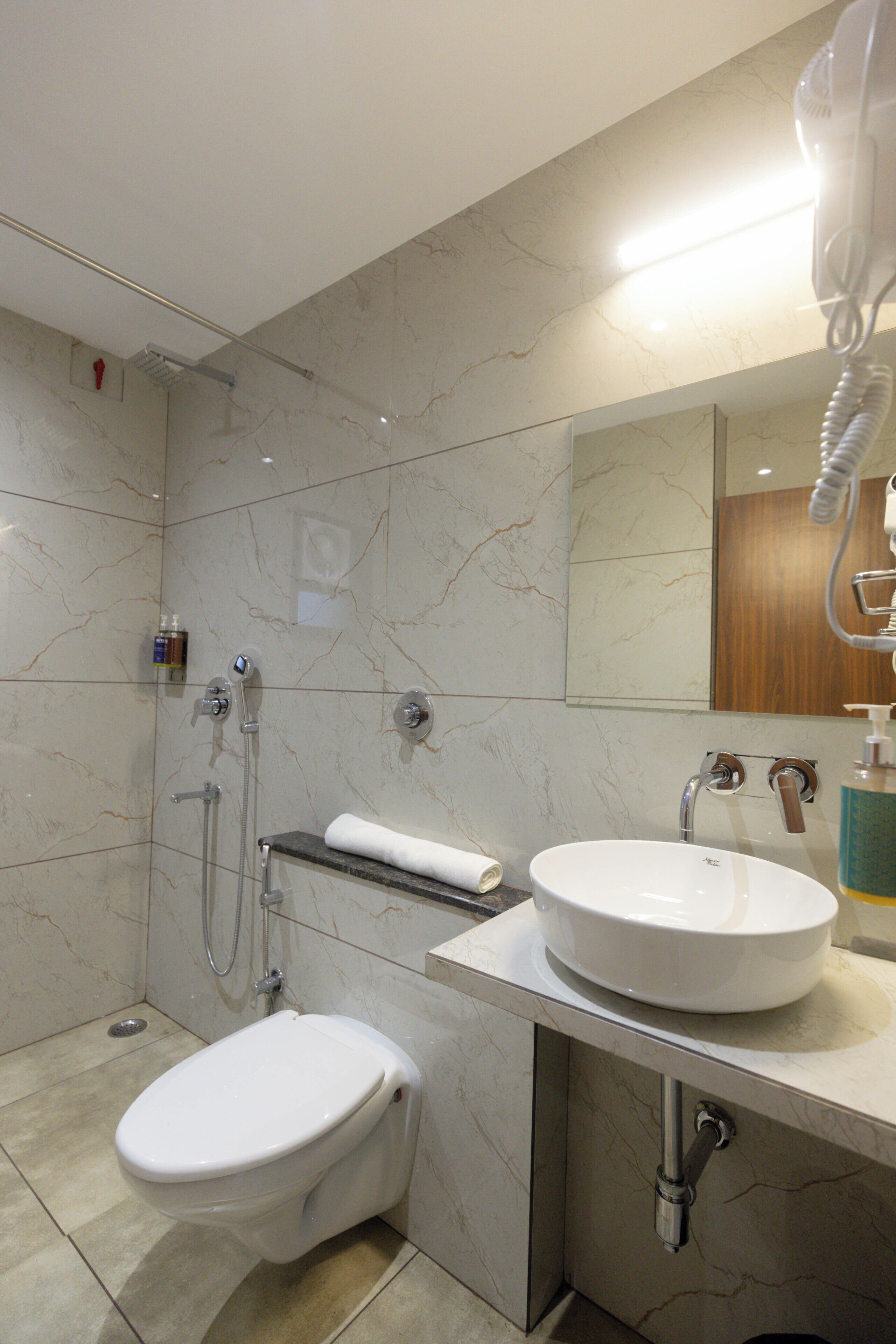 Un baño moderno con inodoro, lavamanos y ducha.