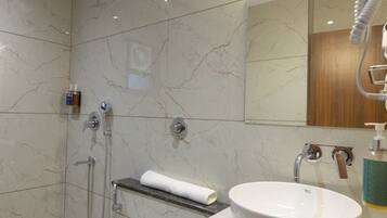 Un baño moderno con inodoro, lavamanos y ducha.