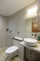 Un baño moderno con inodoro, lavamanos y ducha.