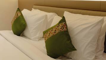 A hotel room with a bed, pillows, a headboard, and wall art.