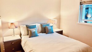 Una camera da letto con un letto, due comodini e una lampada a sospensione.