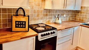 Una cucina con fornello, bollitore e una borsa con l'etichetta 'BUTE YARD'.