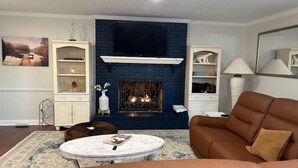Ein Wohnzimmer mit Kamin, einer Couch, einem Couchtisch und Dekoration.