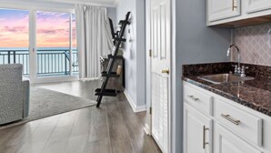 A modern kitchen with white cabinets and a granite countertop.