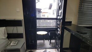 A small kitchen with a black countertop, a white sink, and a small table with chairs. - House 44 (Lagos)