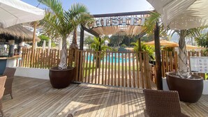 A wooden deck with wicker furniture, a pool, and a sign reading "CHESTER". - Cozy Home With Terrace and Access to Swimming Pool! (Mogan)