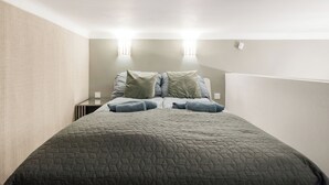 A bedroom with a bed, two bedside tables, and two wall-mounted lights. - Margaret Studio by the Danube near Margaret Island (Budapest)