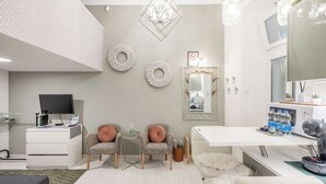 A modern, well-lit room with a desk, two chairs, a mirror, and a television. - Margaret Studio by the Danube near Margaret Island (Budapest)
