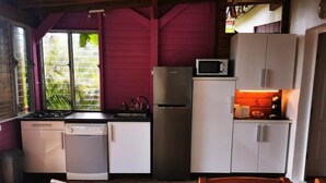 A compact kitchen with a gas stove, dishwasher, refrigerator, microwave, and a small countertop with a coffee maker. - Following the Horizon of the Balisiers (Sainte-Anne)