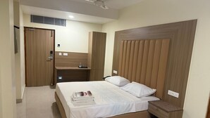 A bedroom with a bed, a wooden headboard, a nightstand, a wardrobe, and a ceiling fan.