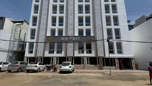 A multi-story building with a modern facade, featuring a central entrance with a sign in a foreign script.