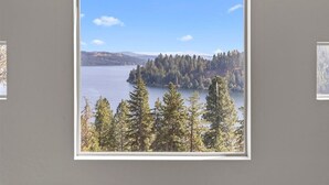 Une photographie encadrée représentant un paysage avec un lac entouré d’arbres et de collines.