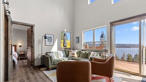 Un salon moderne doté d’une grande fenêtre, d’un canapé, d’une table basse et offrant une vue sur l’extérieur.