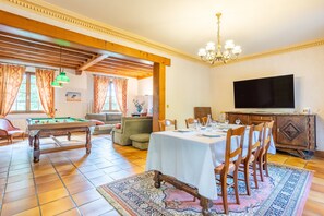 Un espace repas comprenant une table de billard, un téléviseur et une table à manger pour six personnes.