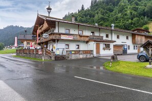 Een klassiek gebouw in de Alpen met een balkon, een bord en een stenen muur.