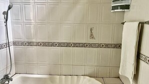 Un baño con bañera, ducha y perchero.
