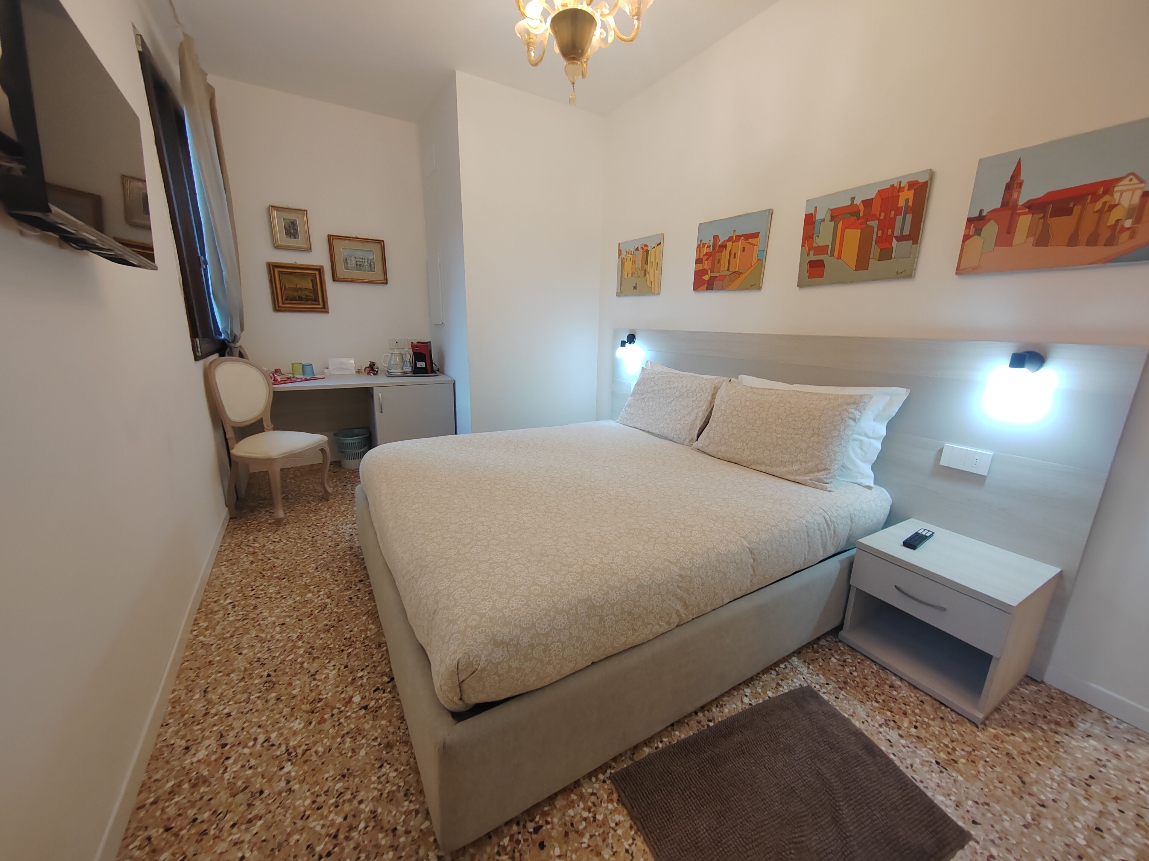 A bedroom with a bed, bedside tables, a desk, and a chair.