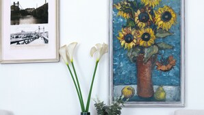 A round table with a vase of flowers and a basket of lemons, flanked by two chairs. - New Town Riverside Apartment (Hlavní město Praha)