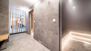 A modern hallway with grey marble walls, a wooden bench, and a glass door leading to a car.