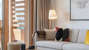 A modern living room with a sofa, a round coffee table, a lamp, and a framed picture on the wall.