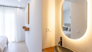 Ein modernes Badezimmer mit einem großen Spiegel, einer Holzauskleidung und einem Waschbecken.