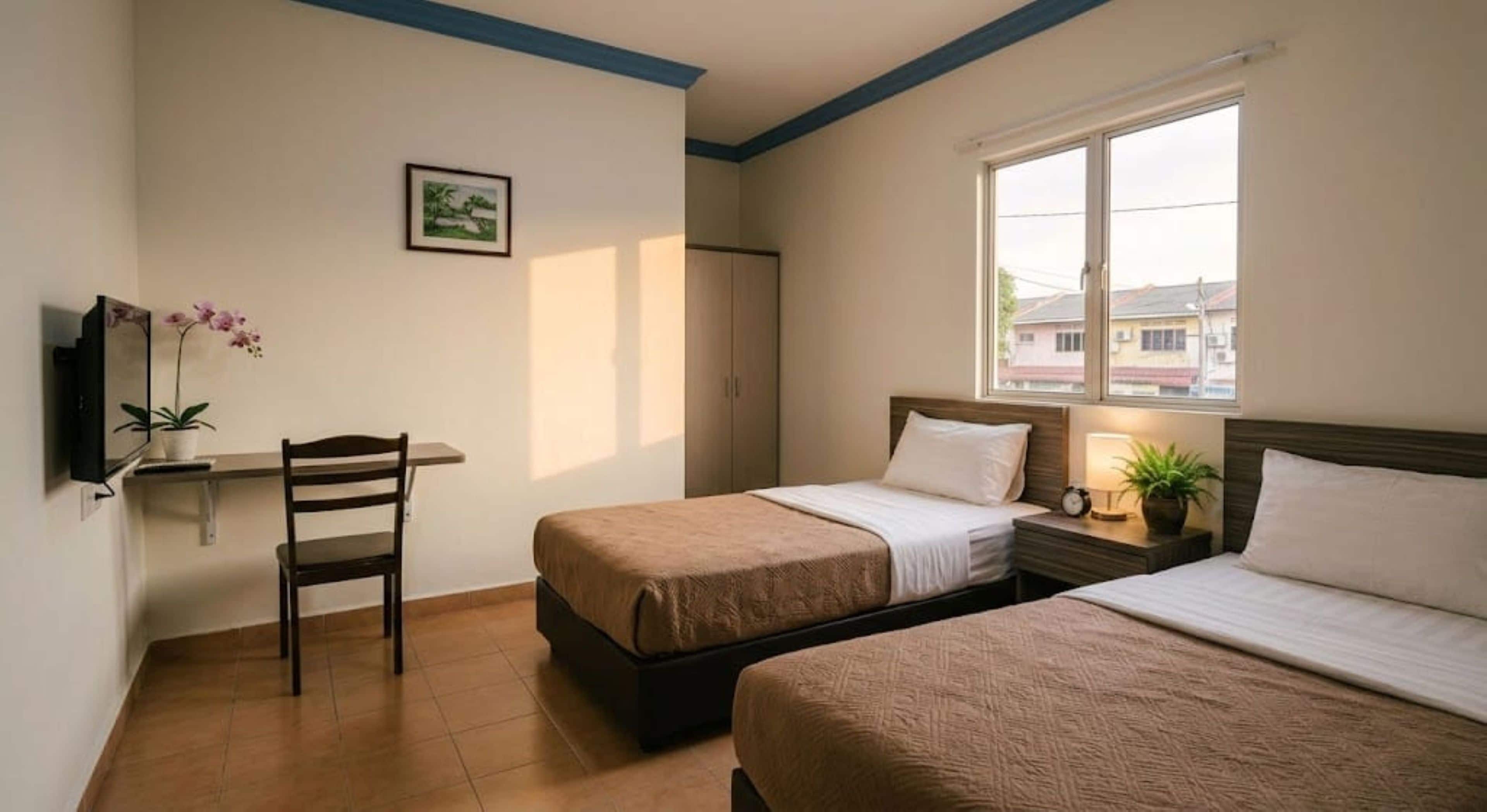 A hotel room with two beds, a desk with a chair, a TV, and a window with a view of buildings.