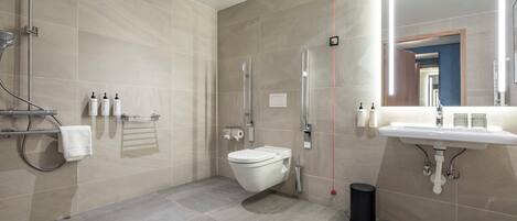 A modern bathroom with a toilet, sink, and shower.