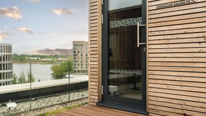 A modern building with a glass door and a sign indicating a sauna temperature of 90°C. - Scanhotels Stadthafen - Neueröffnung (Rostock)
