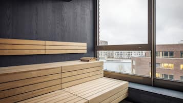 Una habitación moderna con un banco de madera y un ventanal con vistas a un paisaje urbano.