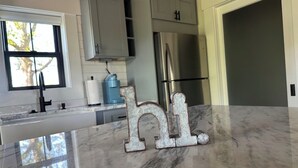 A kitchen with a marble countertop, stainless steel appliances, and a 'hi' decoration. - Charming 1-bedroom house with WiFi and AC in Cowpens (Cowpens)