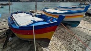 A row of colorful boats docked at a pier with a sign reading "ROSARIO". - ABT L'Aura  (Palermo)