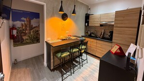 A modern kitchen with wooden cabinets, a bar area, and pendant lighting. - ABT L'Aura  (Palermo)